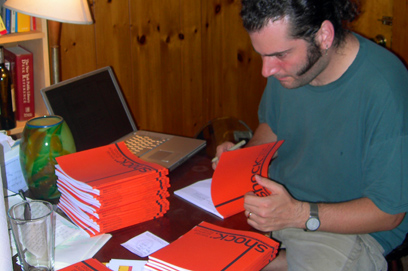 Joshua A.C. Newman signs and numbers the pre-ordered copies of Shock: Social Science Fiction